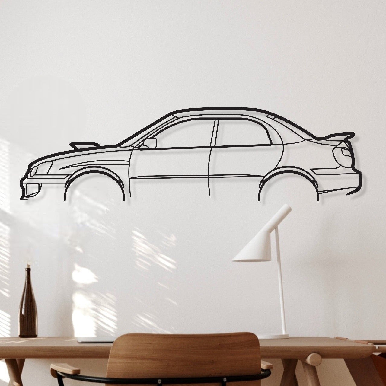 Wooden desk with chair against a white wall with a car outline.