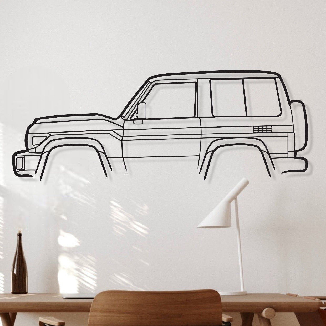 Wooden desk with chair against a white wall with a car decal.