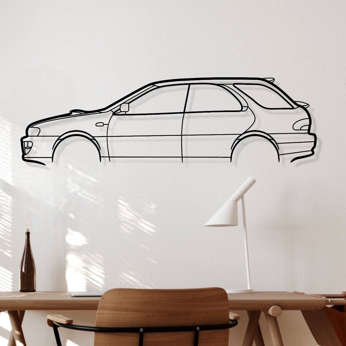 Wooden desk with chair against a white wall with a car outline.