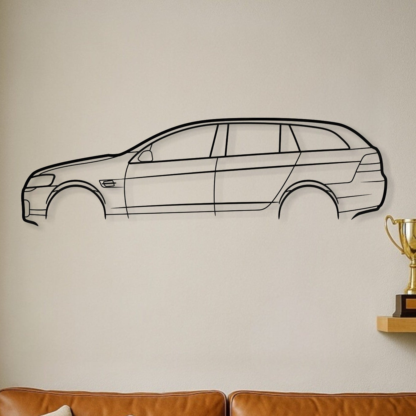 Brown leather sofa with decorative pillows, car wall decal, and trophies on a shelf.