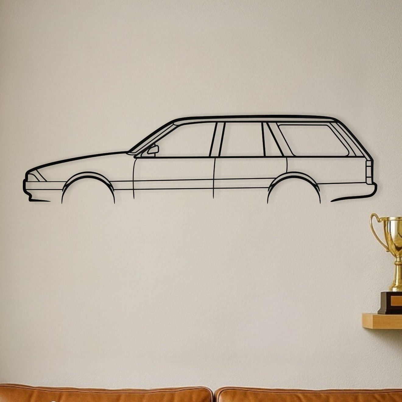 Brown leather sofa with decorative pillows, a wall decal of a car, and trophies on a shelf.