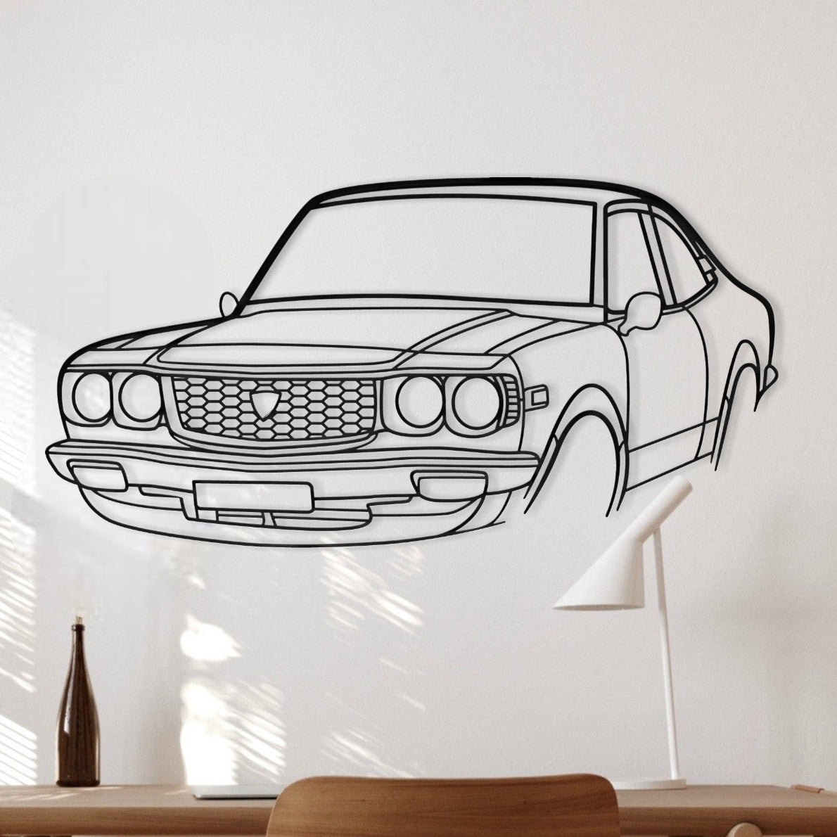 Wooden desk with chair against a wall with a car outline.