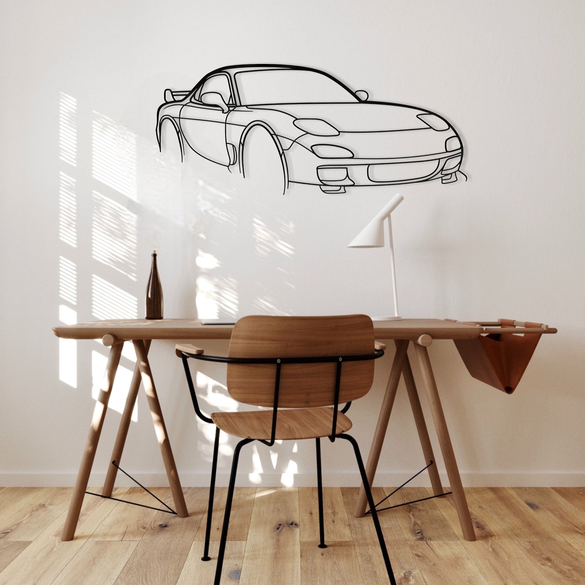 Modern room with wooden desk and chair, wall decal of a car.