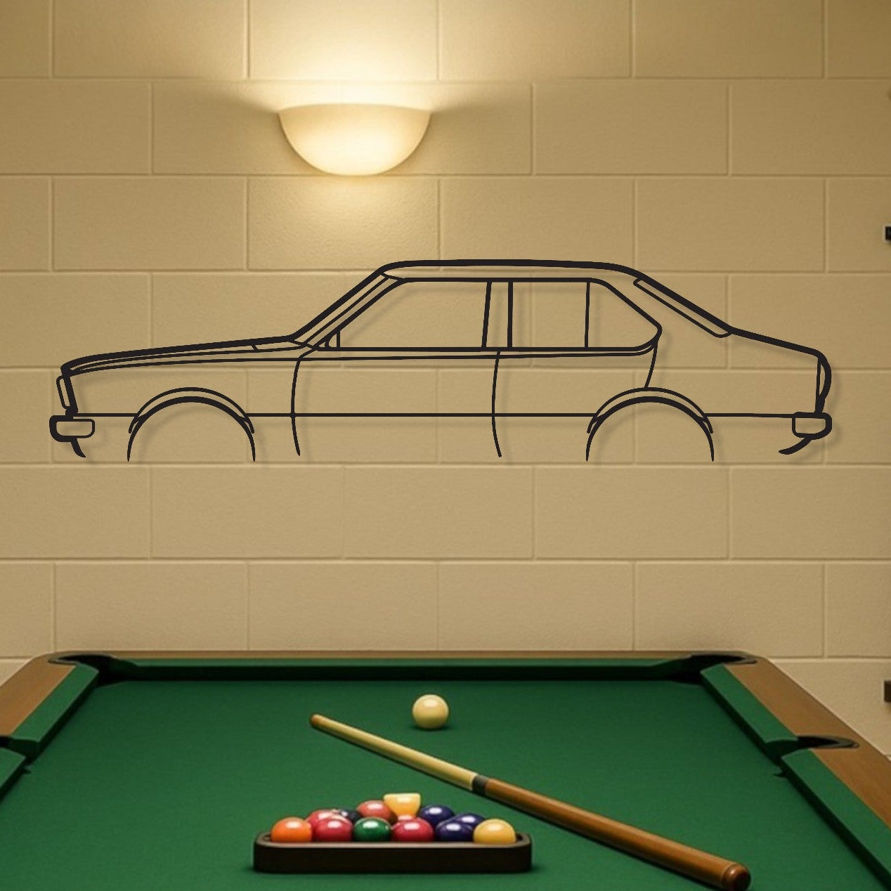 Pool table with billiard balls and cues in a room with a car-shaped wall decal.