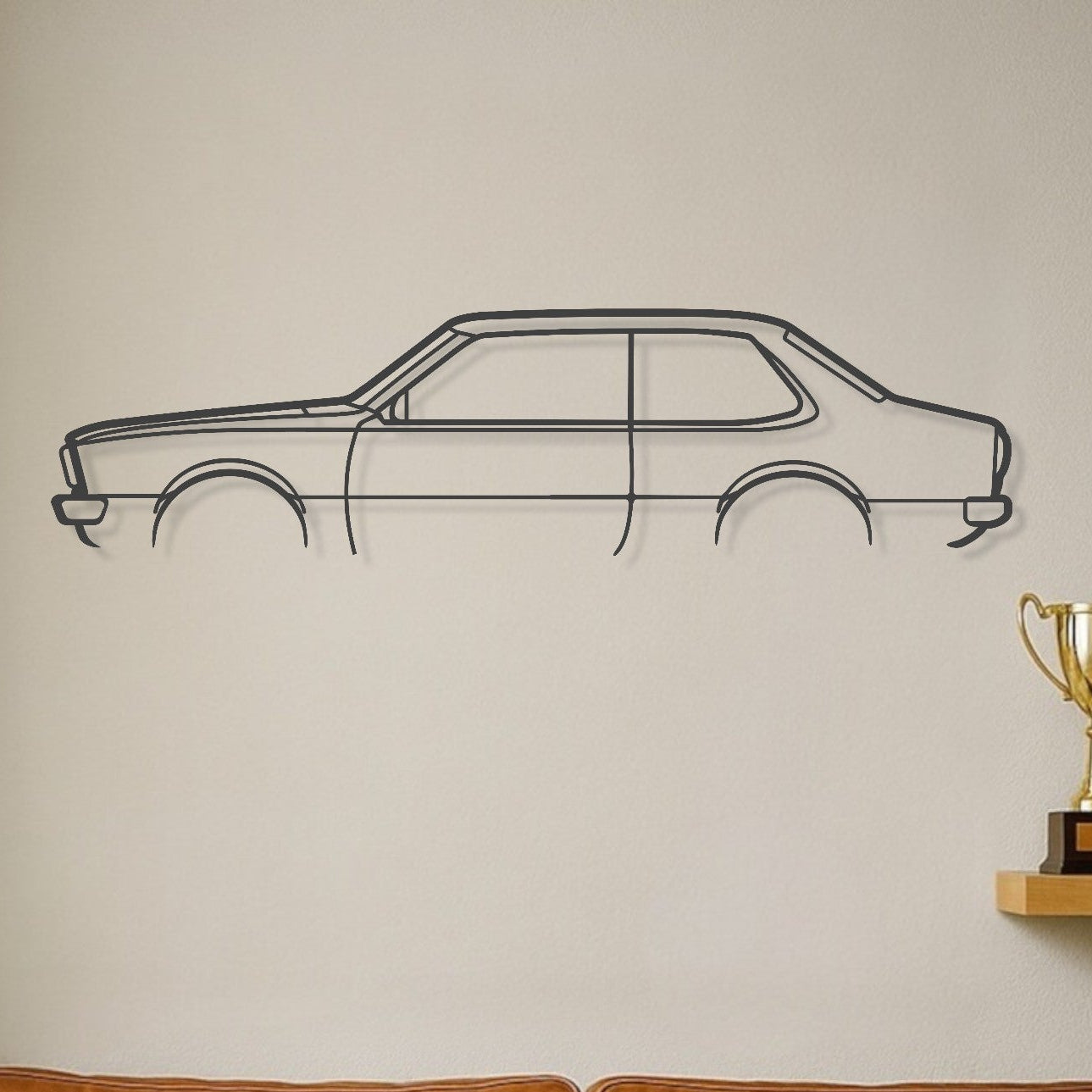 Brown leather sofa with decorative pillows in a room with a car wall decal and trophies on a shelf.