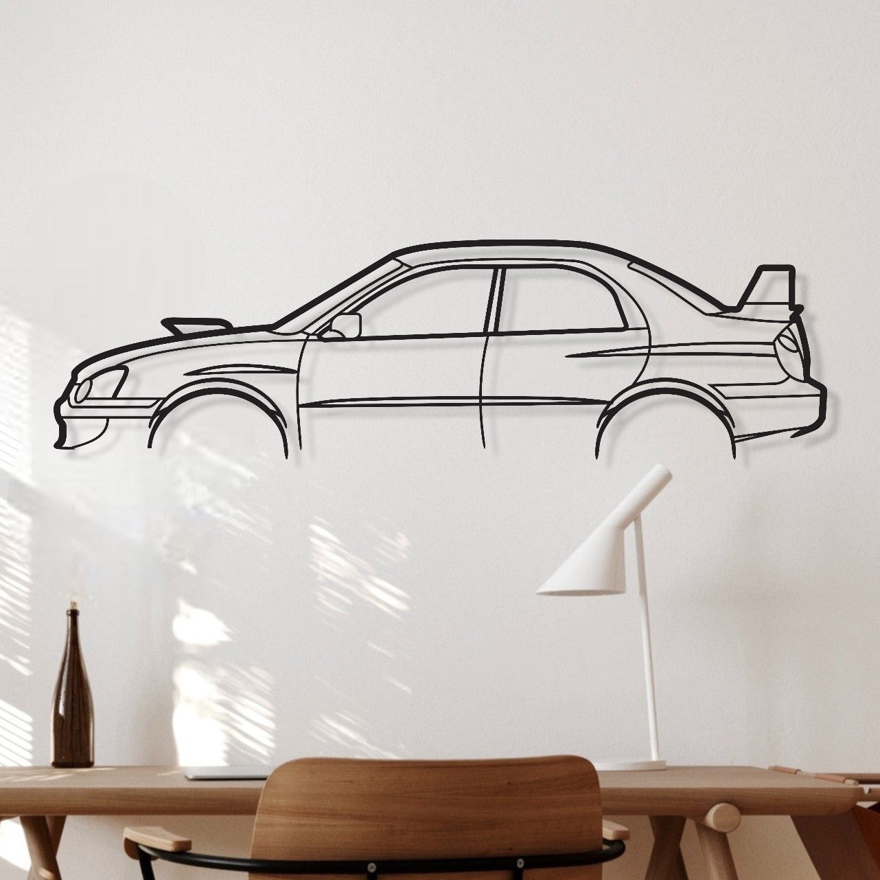 Wooden desk with chair against a white wall with a car outline.