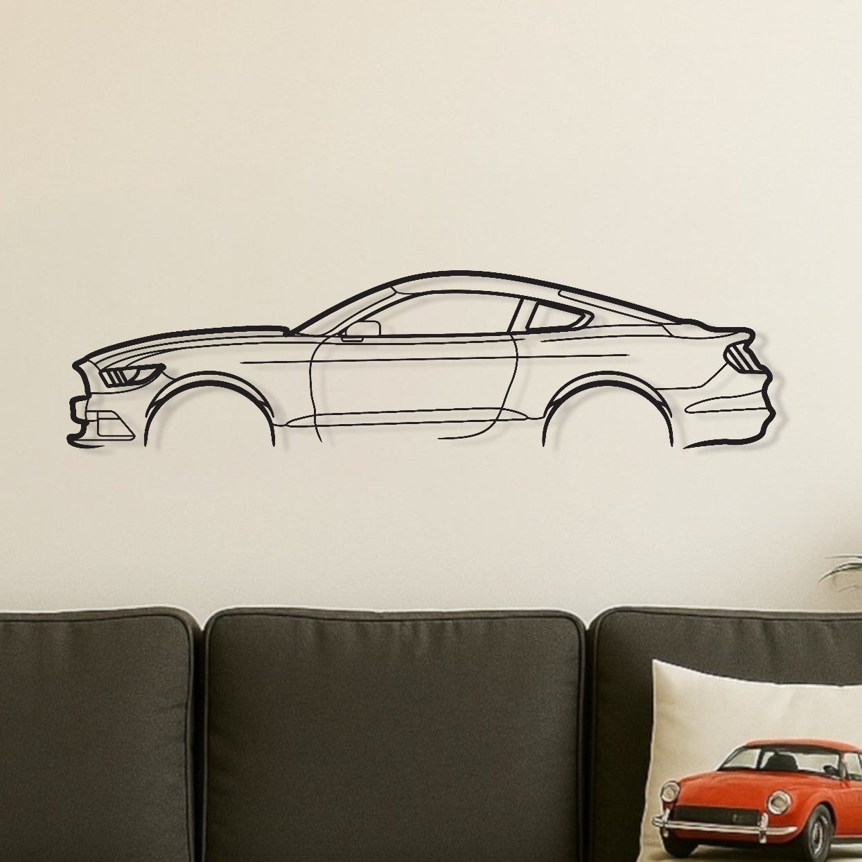 Living room with a gray sofa, wooden coffee table, and decorative car wall decal.