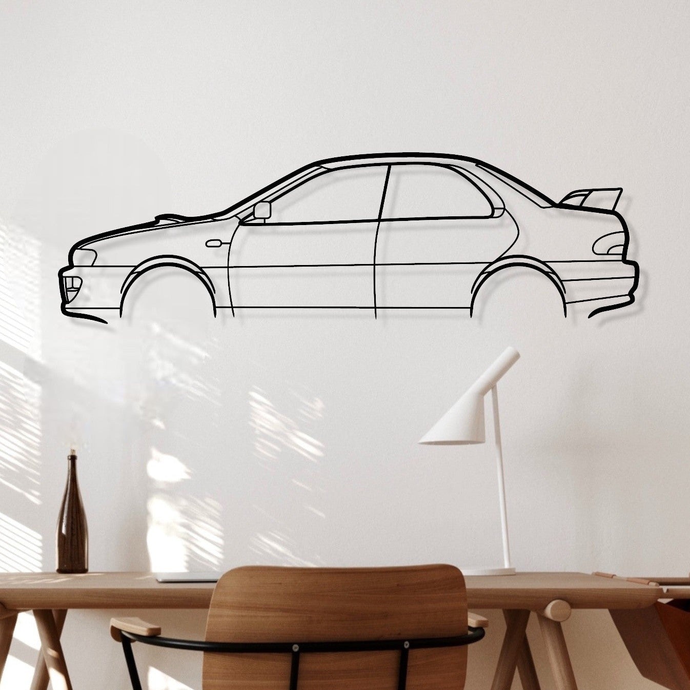 Wooden desk with chair against a white wall with a car outline.