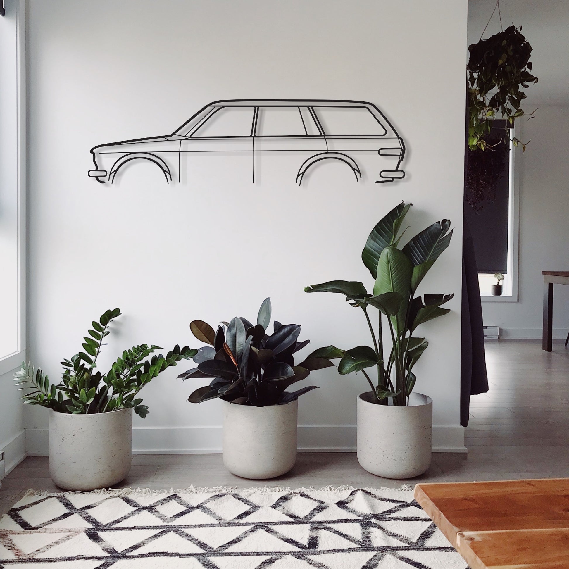 Datsun 1600 auto wall piece in a living room with plants. 