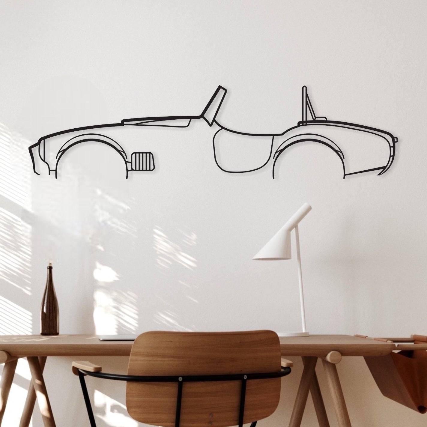 The vintage Ford Cobra metal silhouette wall art piece hanging on an office wall. 