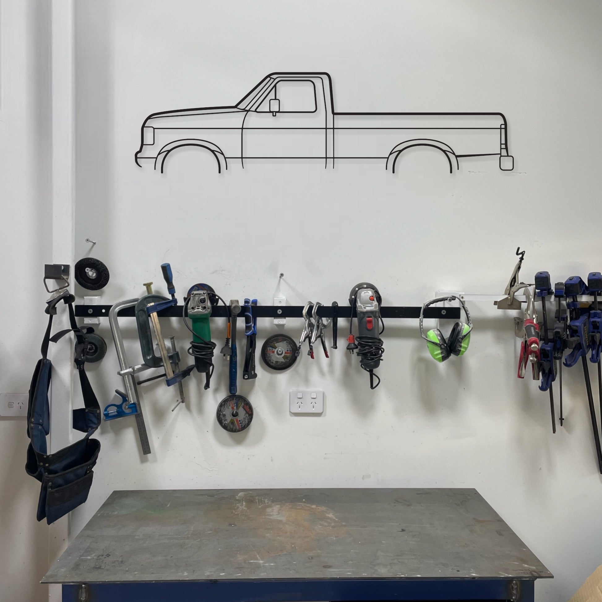 Ford F150 1991 auto art piece  hanging in a shed above work tools and bench.