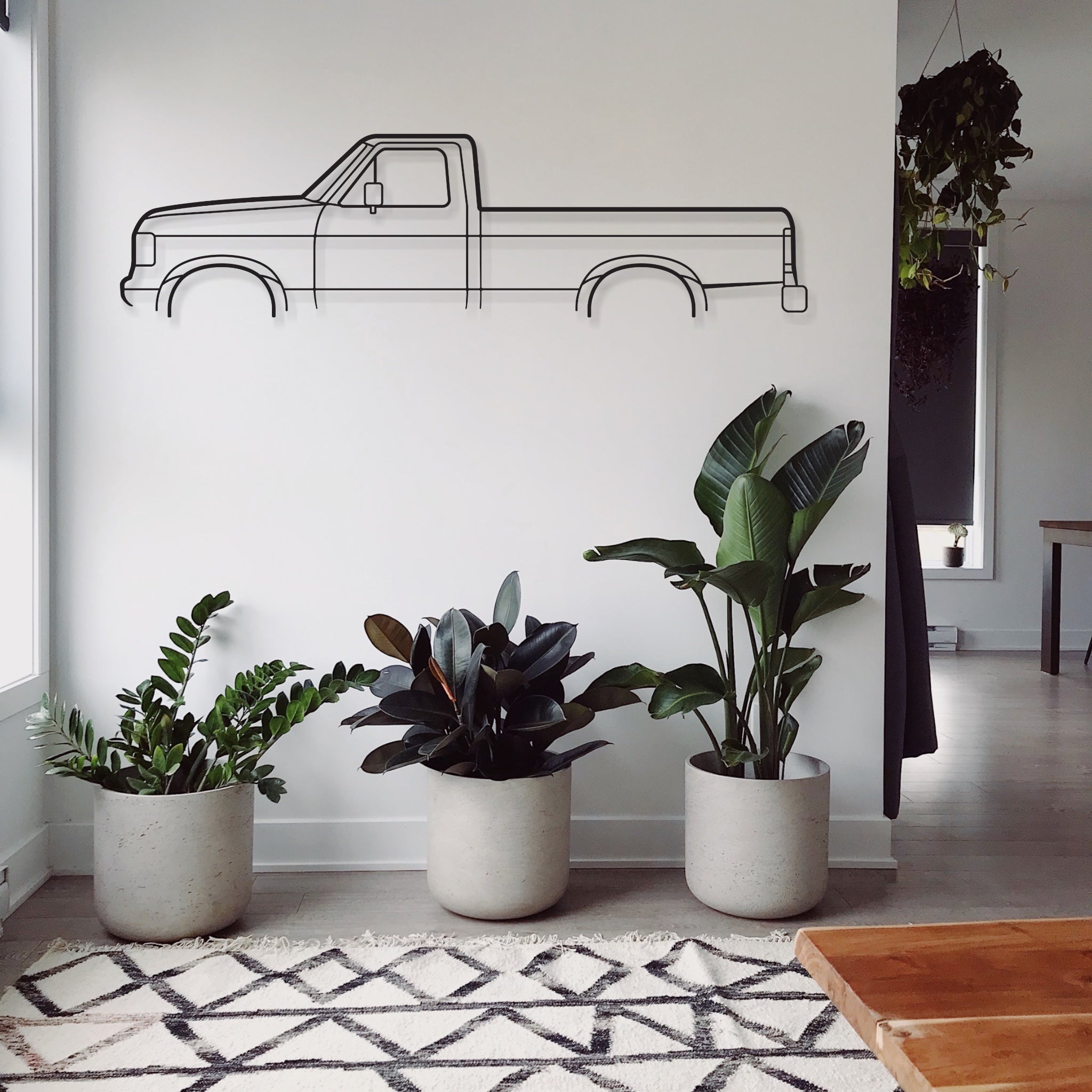 Ford F150 1991 automotive metal wall art hanging above plants in living room.