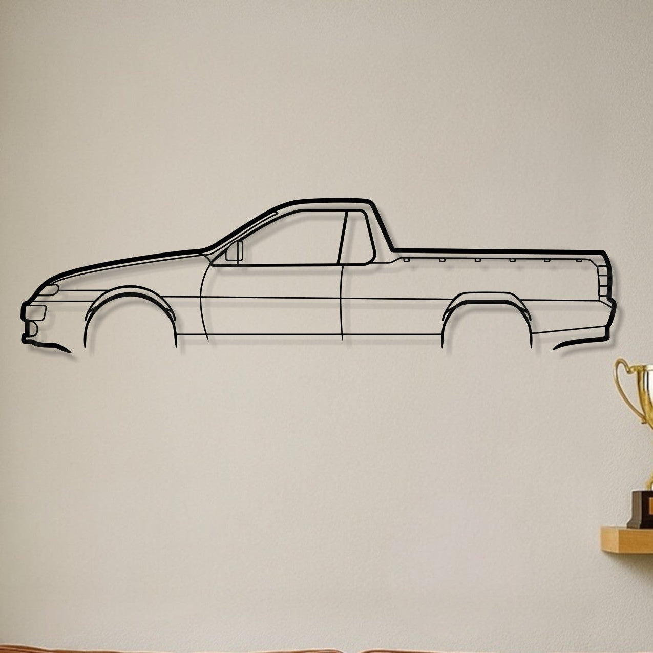 Brown leather sofa with decorative pillows in a room with a car outline on the wall.