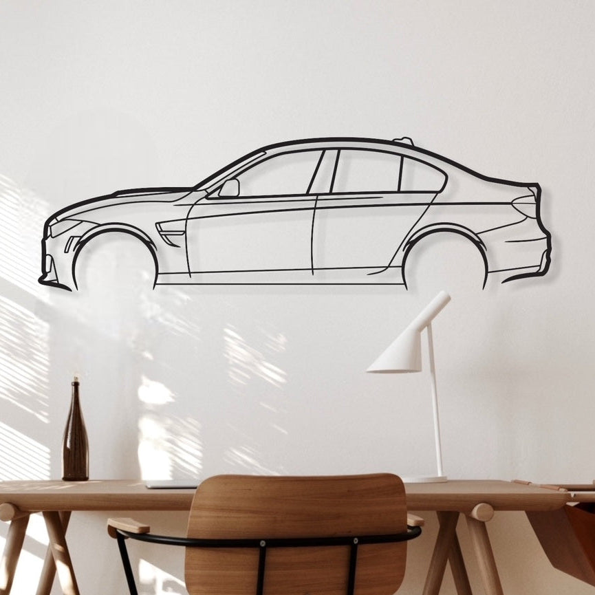 A wall-mounted silhouette of a BMW car drawing, with a wooden desk and chair in the foreground.