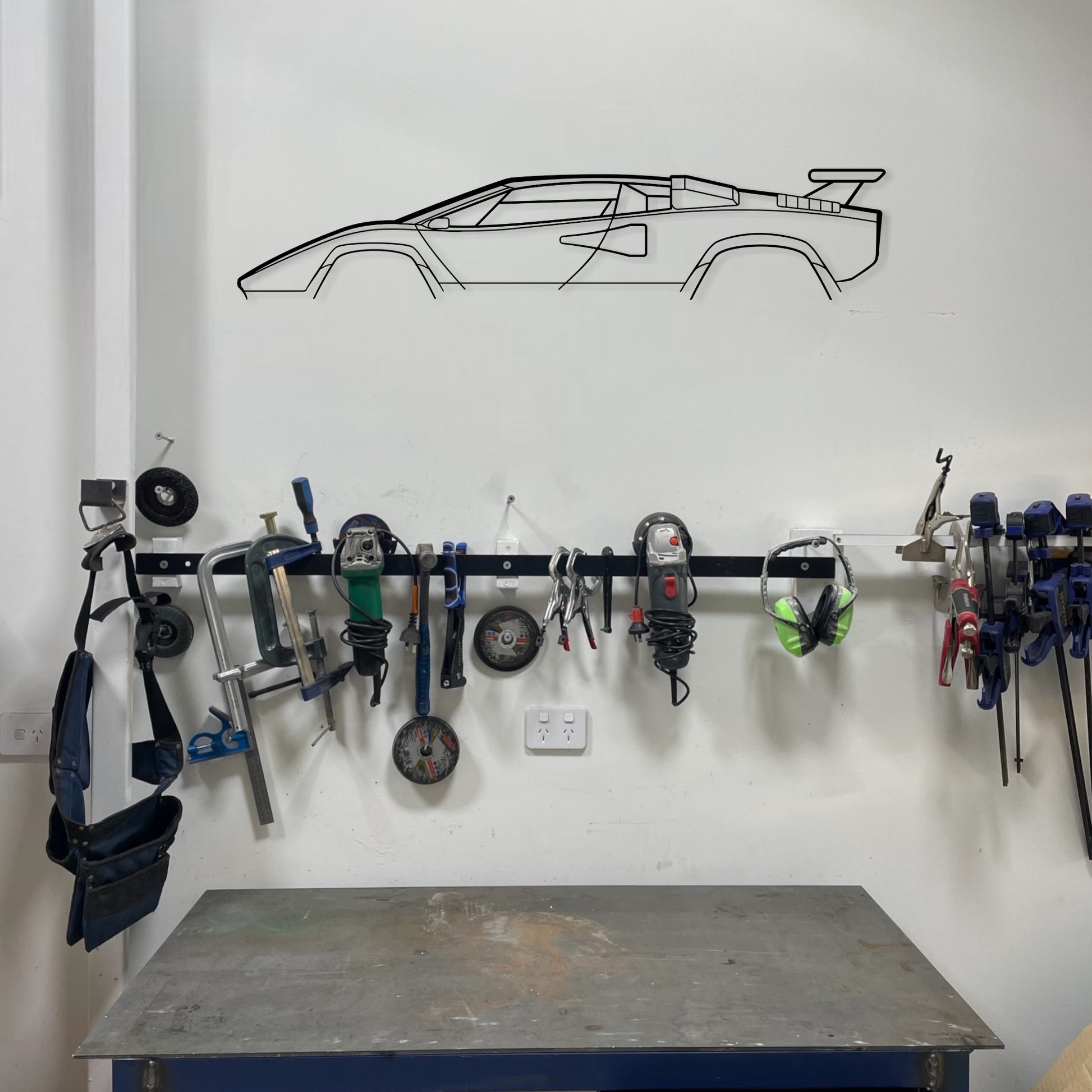 Lamborgini Countach car silhouette wall art on garage wall.