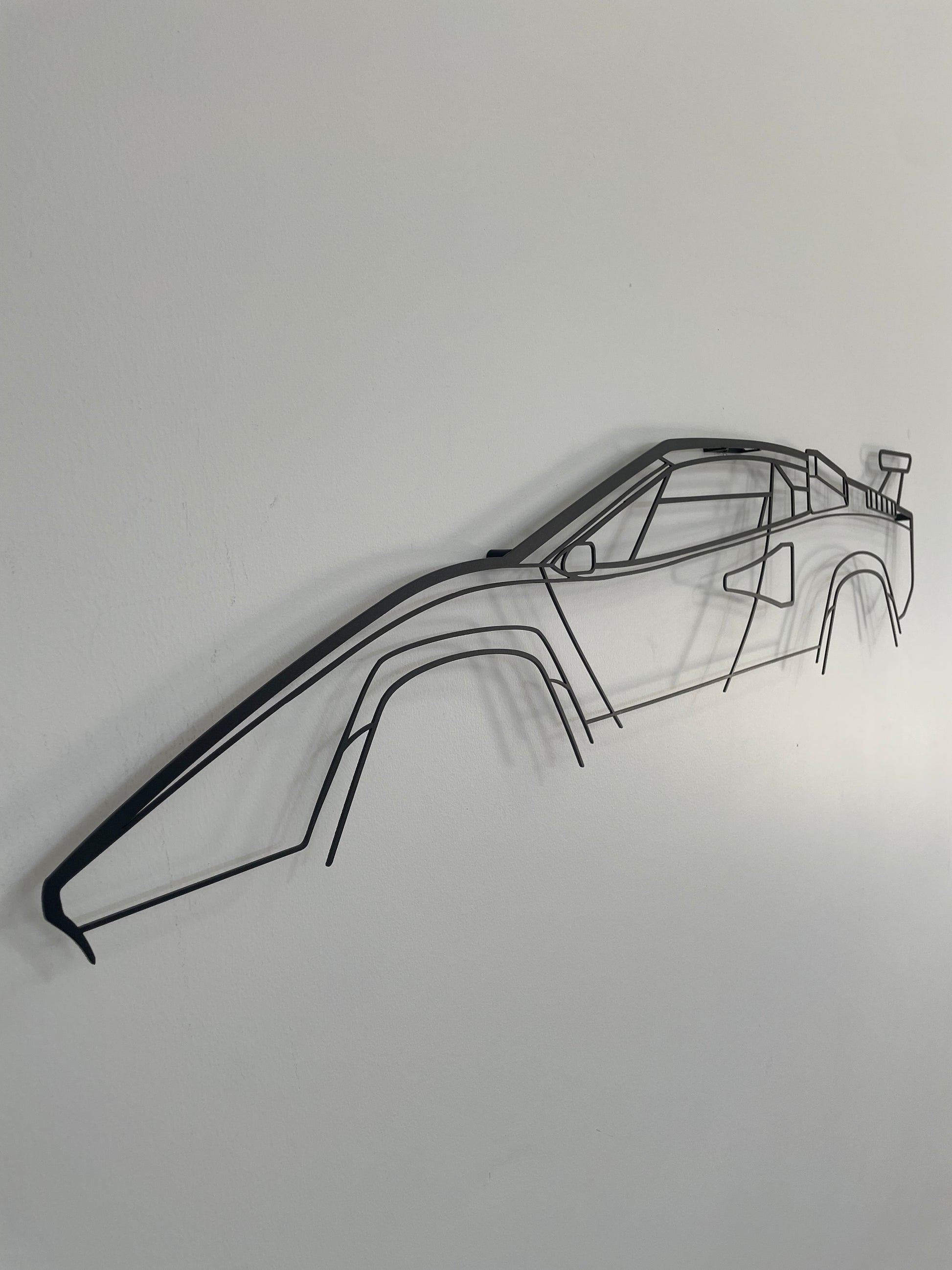 Lamborgini Countach side-on, hung on a white wall.