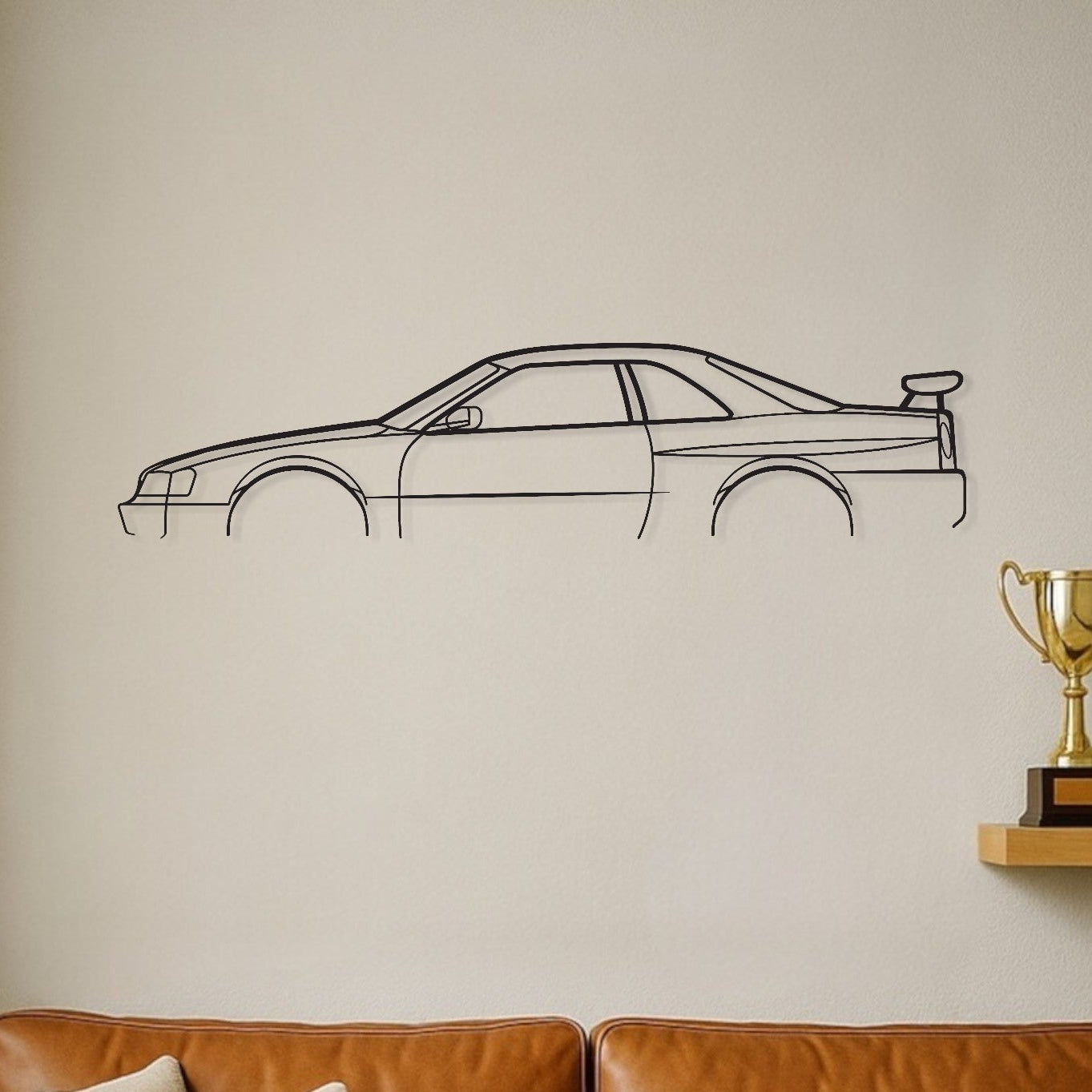 Brown leather sofa with decorative pillows in a room with a car wall decal and trophies on a shelf.