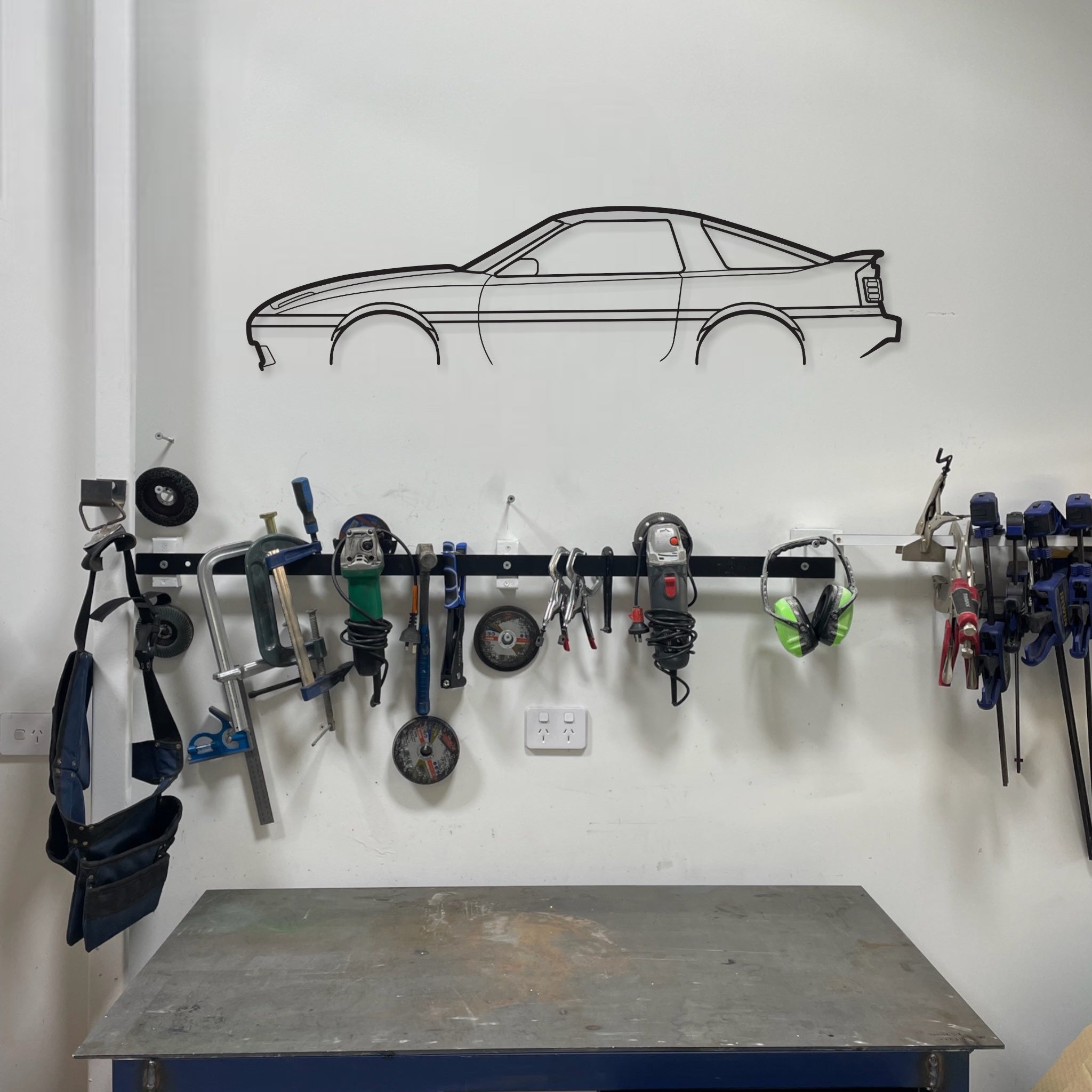 Toyota Supra MA70 auto art wall hanging in a garage above a work bench and tools. 