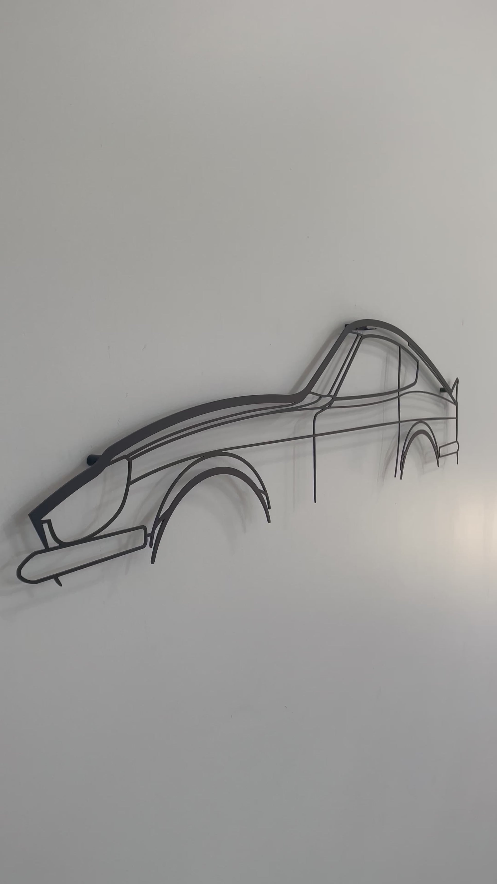 Close up and side on of the large Nissan 240z silhouette car wall hanging on a white wall